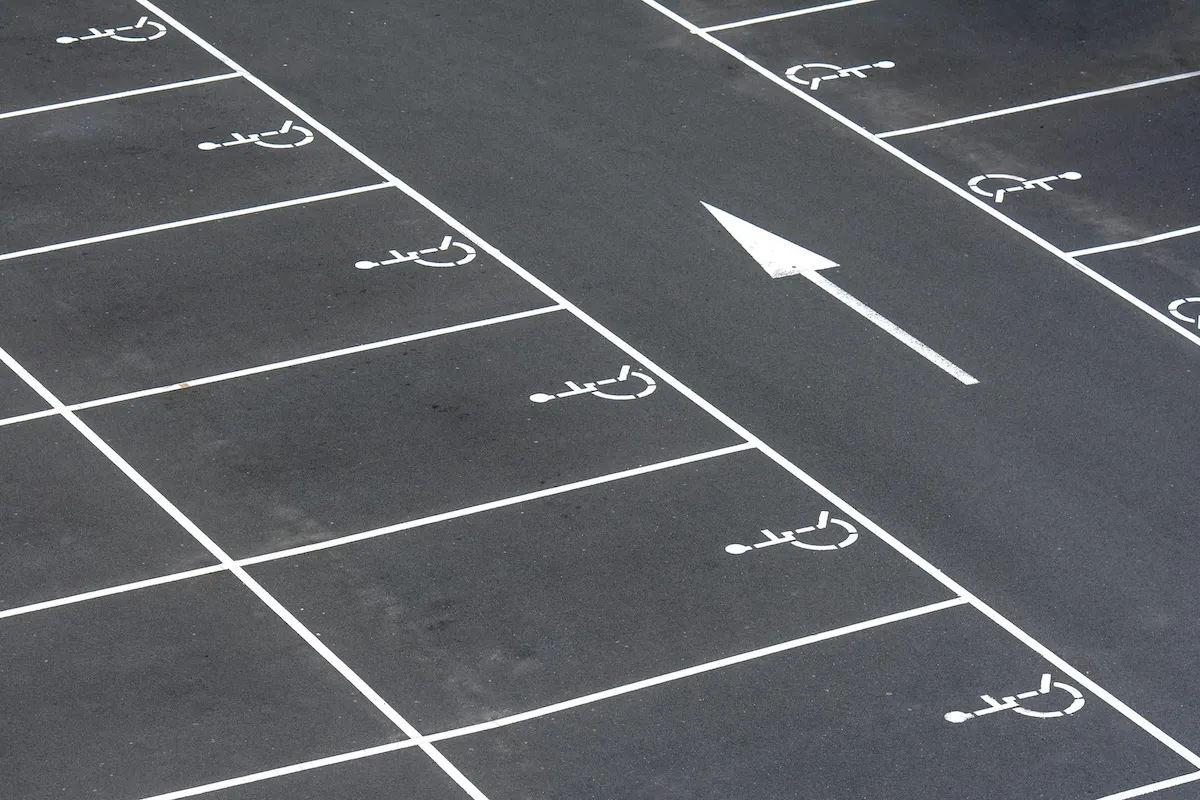 矢印表示と車いすマークが描かれた駐車場の路面
